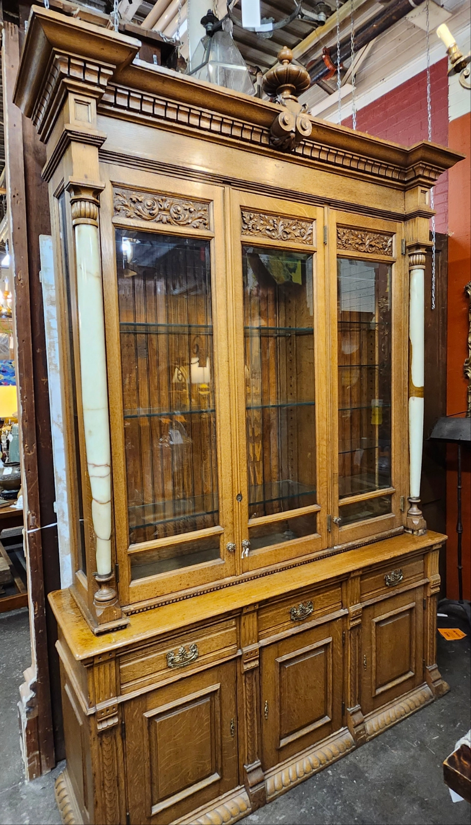 TALL 2 PIECE AMERICAN OAK DISPLAY CABINET WITH BEVELED GLASS DOORS, GLASS SHELVES AND ONYX COLUMNS