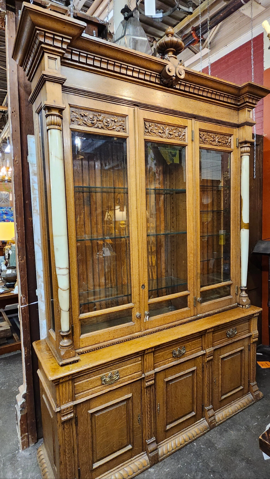 TALL 2 PIECE AMERICAN OAK DISPLAY CABINET WITH BEVELED GLASS DOORS, GLASS SHELVES AND ONYX COLUMNS